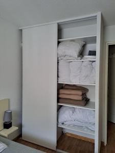 a closet filled with lots of towels and pillows at La Merlerie Super-Besse agréable appartement 5p grand balcon parking privé in Besse-et-Saint-Anastaise