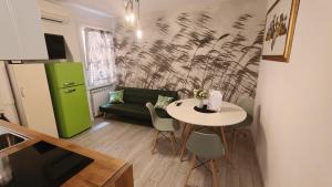 a living room with a table and a green refrigerator at Il Rifugio del Doge in Chioggia