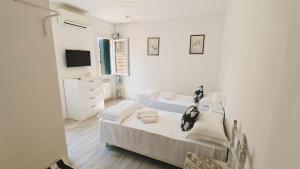 a white bedroom with two beds and a tv at Il Rifugio del Doge in Chioggia +20 photos