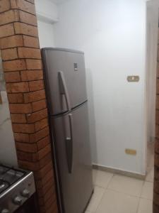 エル・アラメインにある3A Chalet 2 bed rooms without lounge garden view 114 at Green Beachのレンガの壁の隣にあるキッチン(ステンレス製の冷蔵庫付)