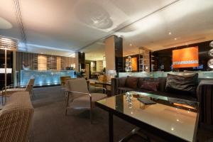 vestíbulo con sofá, mesas y bar en Eurostars Monte Real, en Madrid