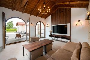 a living room with a couch and a tv at Winnica Maro Apartments 