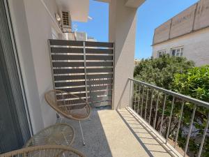 a balcony with two chairs and a railing at Atsiki's 89 Apartments in Chios