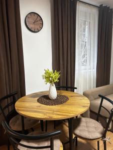 a dining room table with a vase of flowers on it at Apartment Liriq - Free Parking in Sarajevo