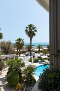 a view of a resort with a pool and palm trees at International Hotel & Suite in San Benedetto del Tronto