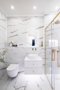 a white bathroom with a toilet and a mirror at Main Square Apartments in Krakow
