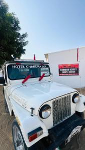 an old white truck parked in front of a building at Chandra Safari Hotel Jaisalmer in Jaisalmer