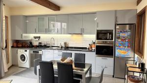 Una cocina con gabinetes blancos y una mesa con sillas. en Escada Villa, en Bicas