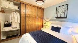 Un dormitorio con una cama con una manta azul y blanca. en Escada Villa, en Bicas