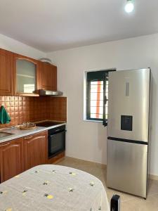 a kitchen with a stainless steel refrigerator and wooden cabinets at Borsh Village Nest in Borsh
