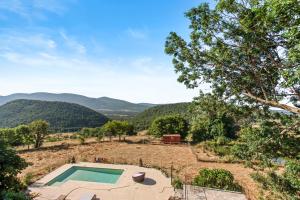 an image of a swimming pool in a field with mountains at Gite Bastide in Bargème