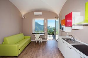 a kitchen with a green couch and a table at Ravello Views Apartment in Ravello