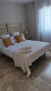 a bedroom with a large bed with two towels on it at Casa Tuca by 7Escalones in Rota