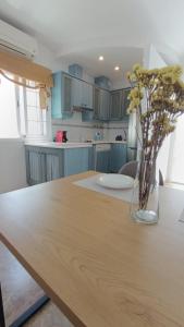 a kitchen with a wooden table with a vase of flowers at Casa Tuca by 7Escalones in Rota