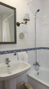 a bathroom with a sink and a mirror and a tub at Casa Tuca by 7Escalones in Rota +12 photos