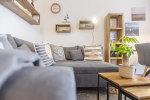 a living room with a gray couch and a table at Ferienwohnung Schmuckstück mit Meerblick Kronsgaard in Kronsgaard +29 photos