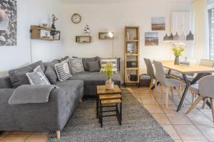 a living room with a gray couch and a table at Ferienwohnung Schmuckstück mit Meerblick Kronsgaard in Kronsgaard