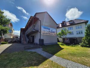 a house with a staircase on the side of it at Noclegi u Loni - Szary domek - noclegi w zacisznym centrum Pobierowa nad morzem z parkingiem in Pobierowo +52 photos