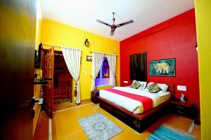 a bedroom with red and yellow walls and a bed at Chandra Safari Hotel Jaisalmer in Jaisalmer +4 photos