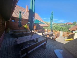 a group of benches with umbrellas on a patio at Penzion Ždiar in Ždiar