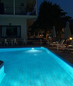 a swimming pool lit up at night at Aliston Hotel Thassos in Skala Potamias