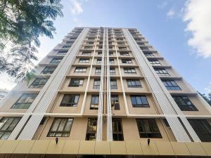 un grand bâtiment avec des fenêtres sur le côté dans l'établissement Boho, Breezy, Sun-Kissed 2bhk nr BKC & Airport, à Mumbai