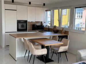 a kitchen with a wooden table and chairs at Apartmen ARMINAN 52 TERRACE, POOL FREE PARKING -NOVIGRAD in Novigrad Istria