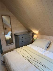 a attic bedroom with a bed and a mirror at Domki Lawendowe in Sasino