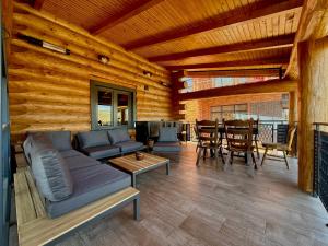 a living room with a couch and a table at Al Tronco Log Cabin in Cîmpeneşti