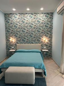 una camera da letto con un letto e un muro di pietra di Porta Marina Pompei Resort a Pompei