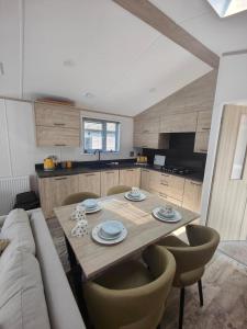 a kitchen with a wooden table and a couch at Honey Bee Lodge With Hot Tub in York