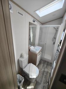 a small bathroom with a toilet and a sink at Honey Bee Lodge With Hot Tub in York
