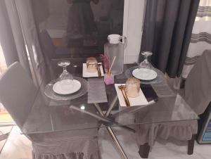 a glass table with two plates and glasses on it at NAJJ Inn in Siquijor +1 photo