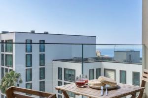 a table on a balcony with a view of a building at Acqua Residence VI by An Island Apart in Funchal