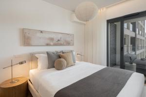 a bedroom with a large white bed with pillows at Acqua Residence VI by An Island Apart in Funchal