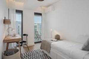 a bedroom with a bed and a desk and a window at Acqua Residence VI by An Island Apart in Funchal