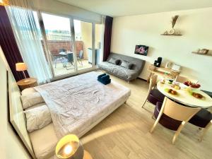 ルルドにある" Escale Closeraie " Balcon - Parking - 4 personnesのベッドとテーブルのある小さな部屋とダイニングルームのある部屋