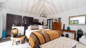 ein Schlafzimmer mit 2 Betten und einem Stuhl darin in der Unterkunft Utmost Luxury In The Heart Of Tropical Nature in Marigot