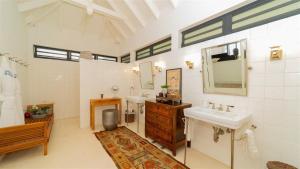 ein Badezimmer mit Waschbecken und Spiegel in der Unterkunft Utmost Luxury In The Heart Of Tropical Nature in Marigot + 19 Fotos