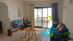 a living room with a blue couch and a table at Romantic Chalete قرية الغرندل in Ras Sedr