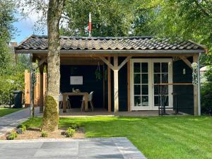 a gazebo with a table in a yard at Chalet Aan de rand - Veluwe - met sauna in Putten