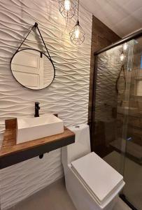 a bathroom with a sink and a toilet and a mirror at Casa com Piscina, a 5 min da COP 30 in Belém