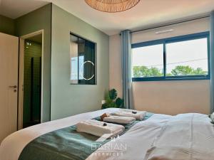 a bedroom with a bed with towels on it at La Maévague - Villa 4 étoiles - Voyage entre mer et monde in Fouras +44 photos