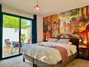a bedroom with a large bed with a painting on the wall at La Maévague - Villa 4 étoiles - Voyage entre mer et monde in Fouras