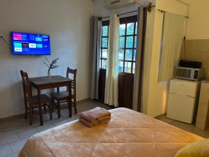 a bedroom with a bed and a table and a tv at Pequeño Monoambiente céntrico 1E in Puerto Iguazú +13 photos