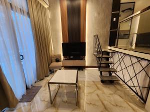 达沃市The Loft Unit 5的一间带楼梯和电视的客厅