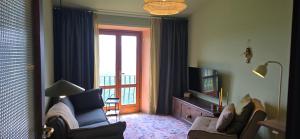 a living room with a couch and a tv and a window at La Casa del Tramonto in Vellano