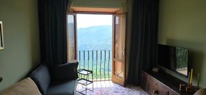 a living room with a view of a balcony with a television at La Casa del Tramonto in Vellano