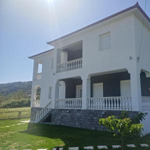 a white house with a hill in the background at Summer Paradise in Paralia Sikias