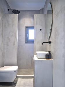 a bathroom with a toilet and a sink and a mirror at Parousia Luxury Apartments in Kampos Paros +65 photos